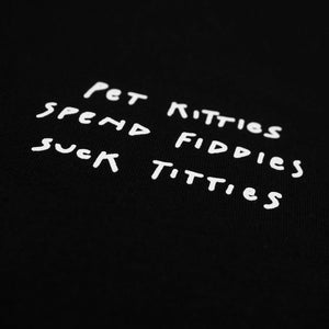 Close up of the text "pet kitties, spend fiddies, suck titties" written in white colour on a black shirt on the left chest