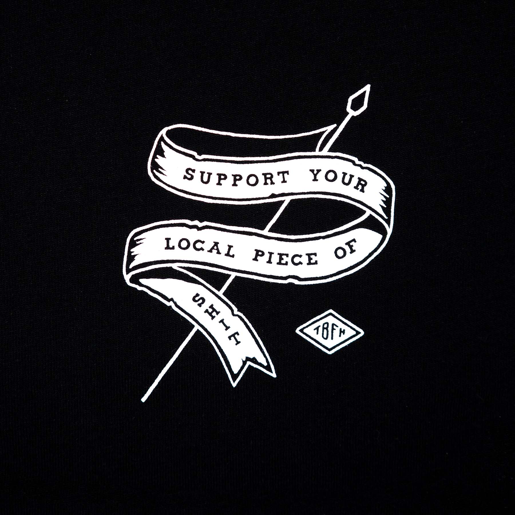 Close up of the text "support your local piece of shit" screen-printed in white colour on a black shirt on the left chest