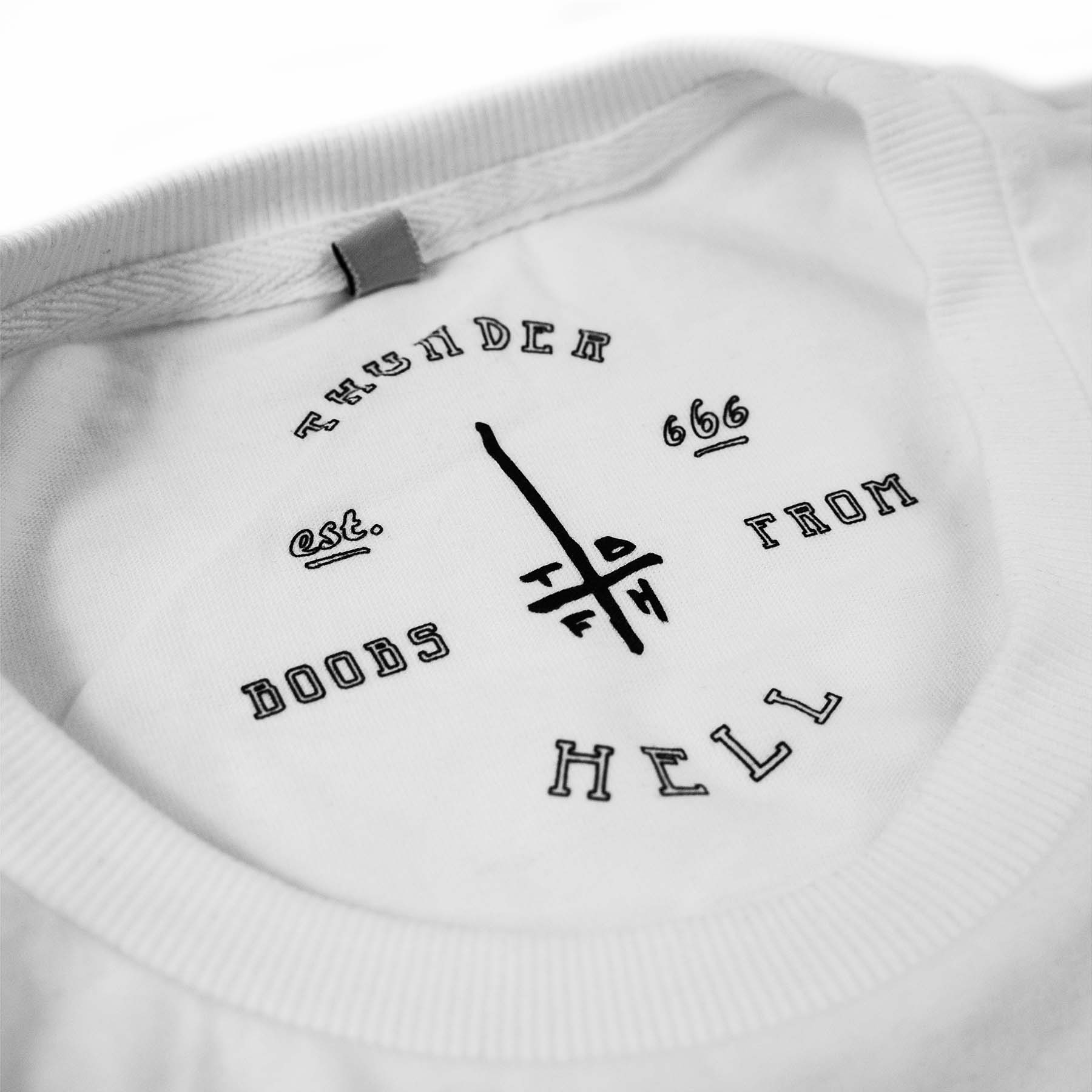 Close up of the black neck printing saying " thunder boobs from hell and est. 666 with the tbfh logo in the middle" screen-printed on a white shirt